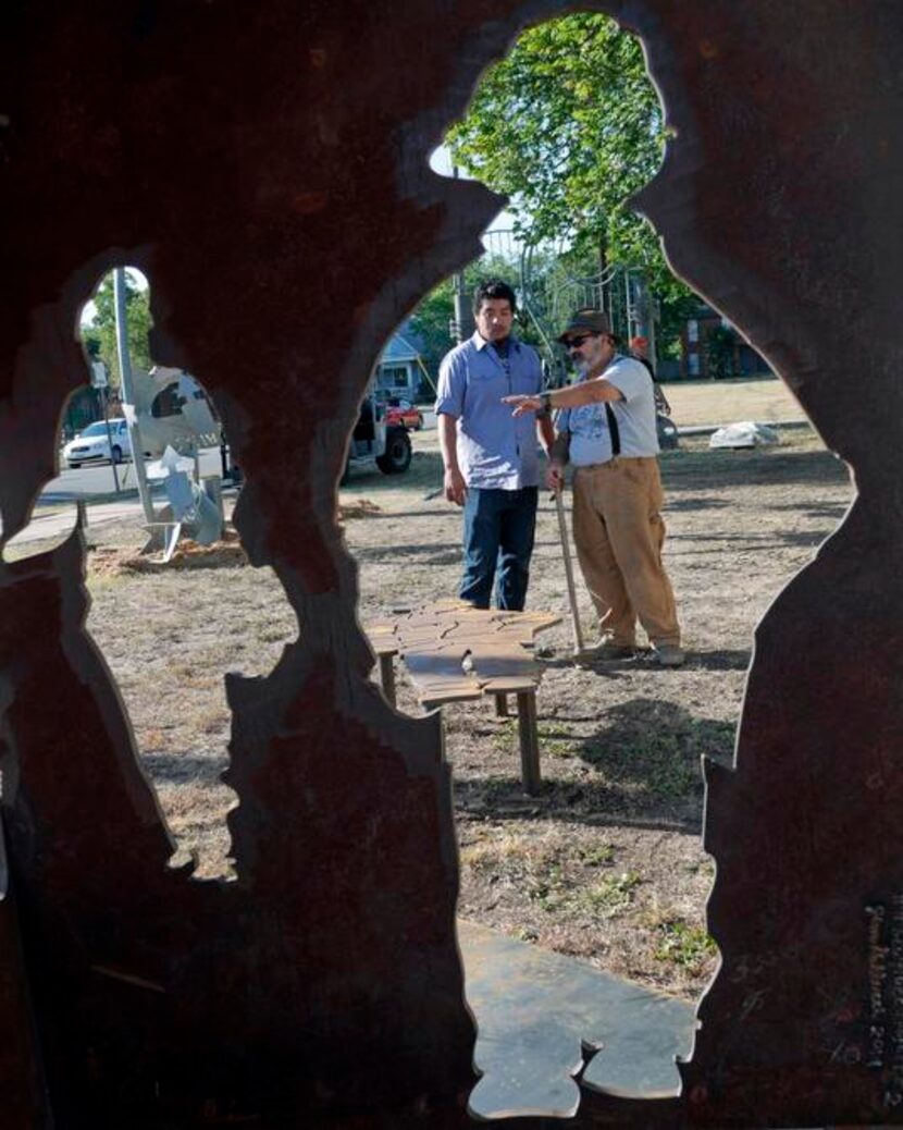 
Jose Diaz (left) and sculptor Jim Gallucci figure out where to place the firefighter...