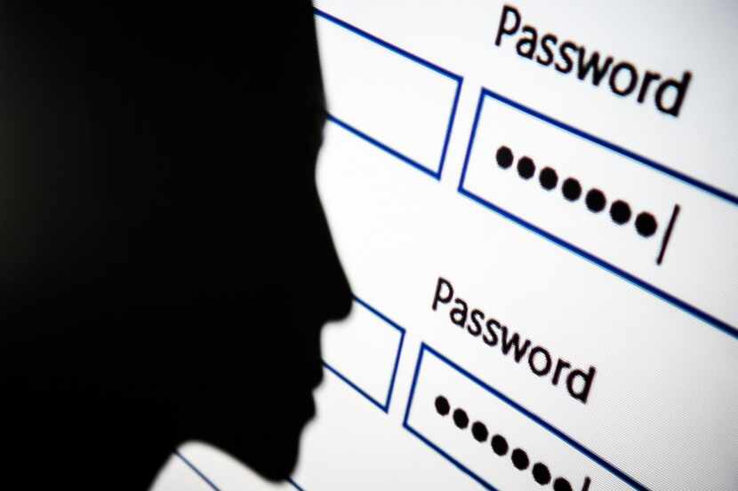  In this photo illustration, A woman is silhouetted against a projection of a password...