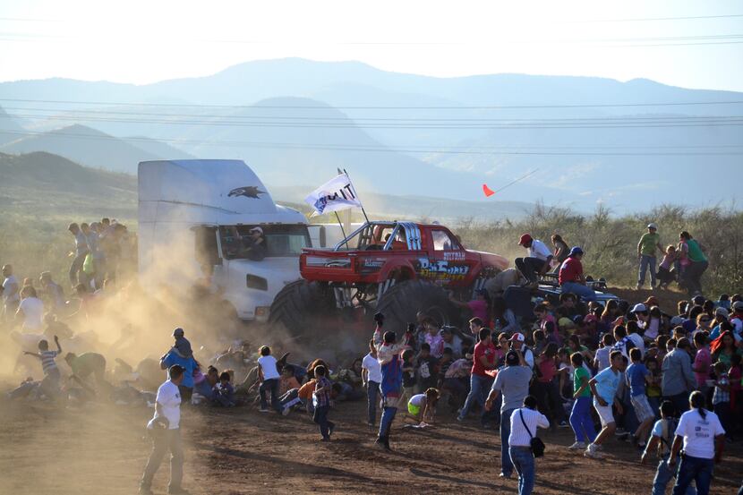 People run as an out of control monster truck plows through a crowd of spectators at a...