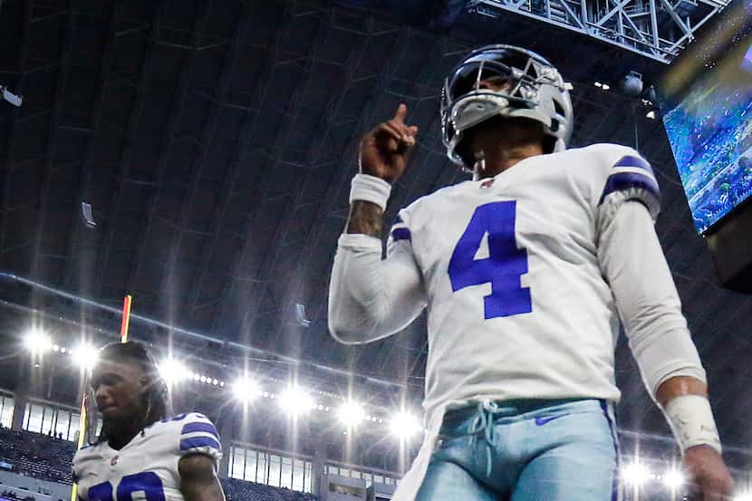 Dallas Cowboys quarterback Dak Prescott (4) points skyward as he comes off the field...
