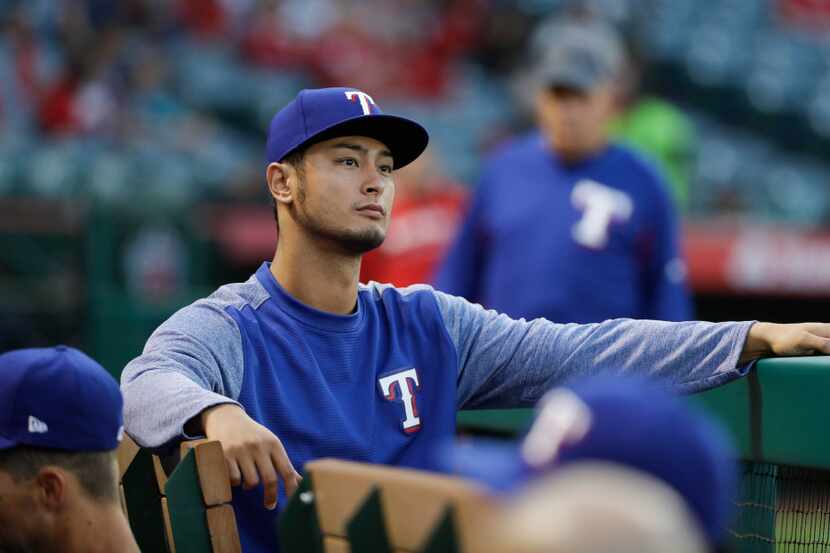 Texas Rangers starting pitcher Yu Darvish, of Japan, sits in the dugout before the team's...