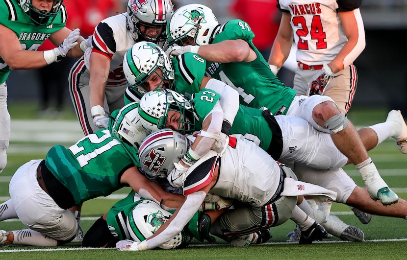 The Southlake Carroll defensive stuffs Flower Mound Marcus wide receiver Karic Grennan...