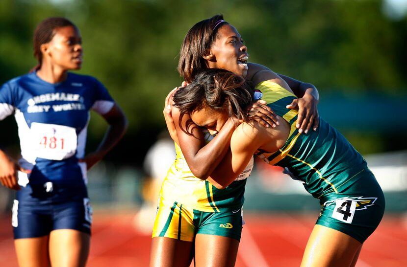 DeSoto's Chrishuna Williams, center hugs Kierra Hamilton, right, after they finished second...