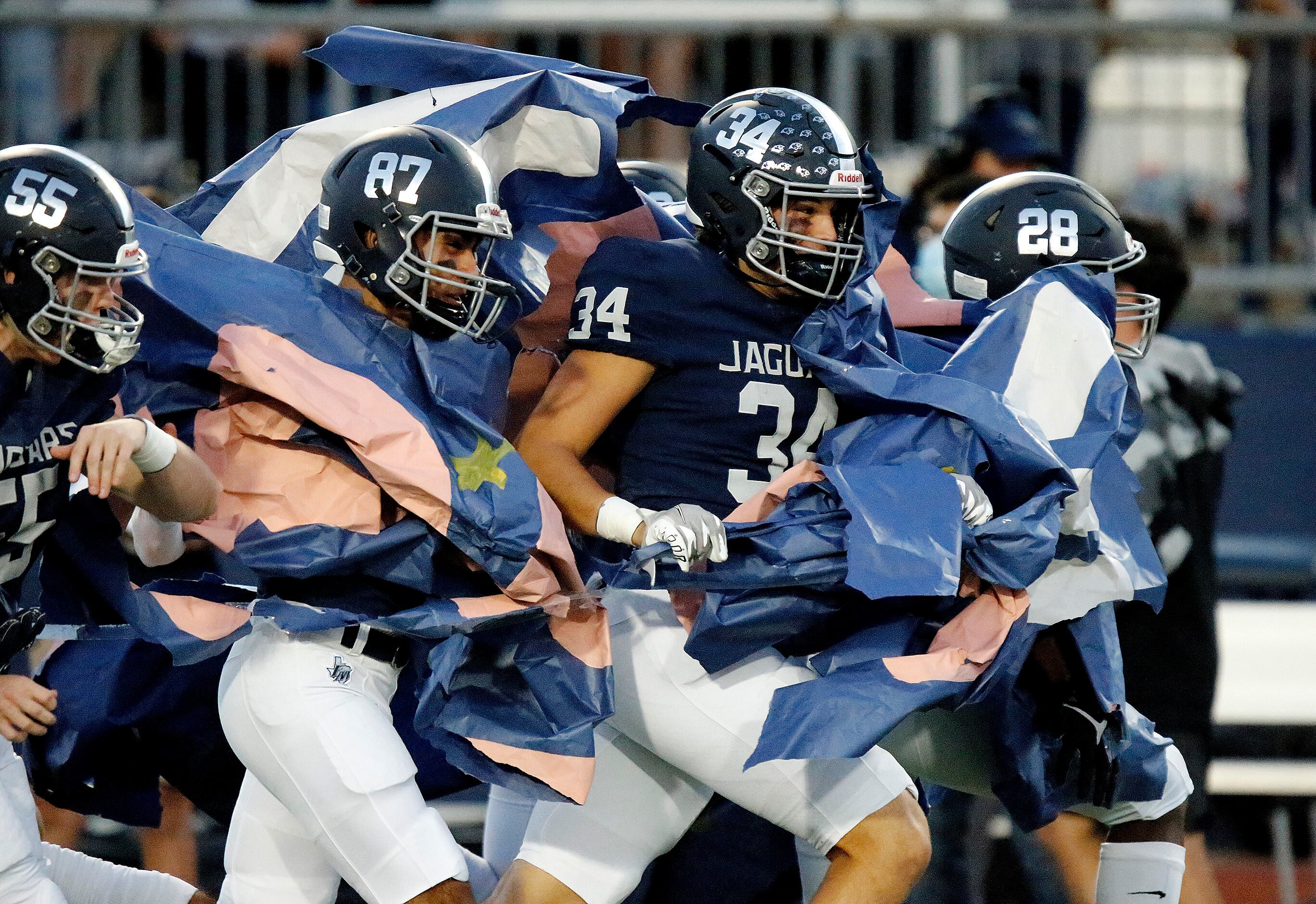 Flower Mound High School defensive end Luke Browning (34) hits the run through as his team...