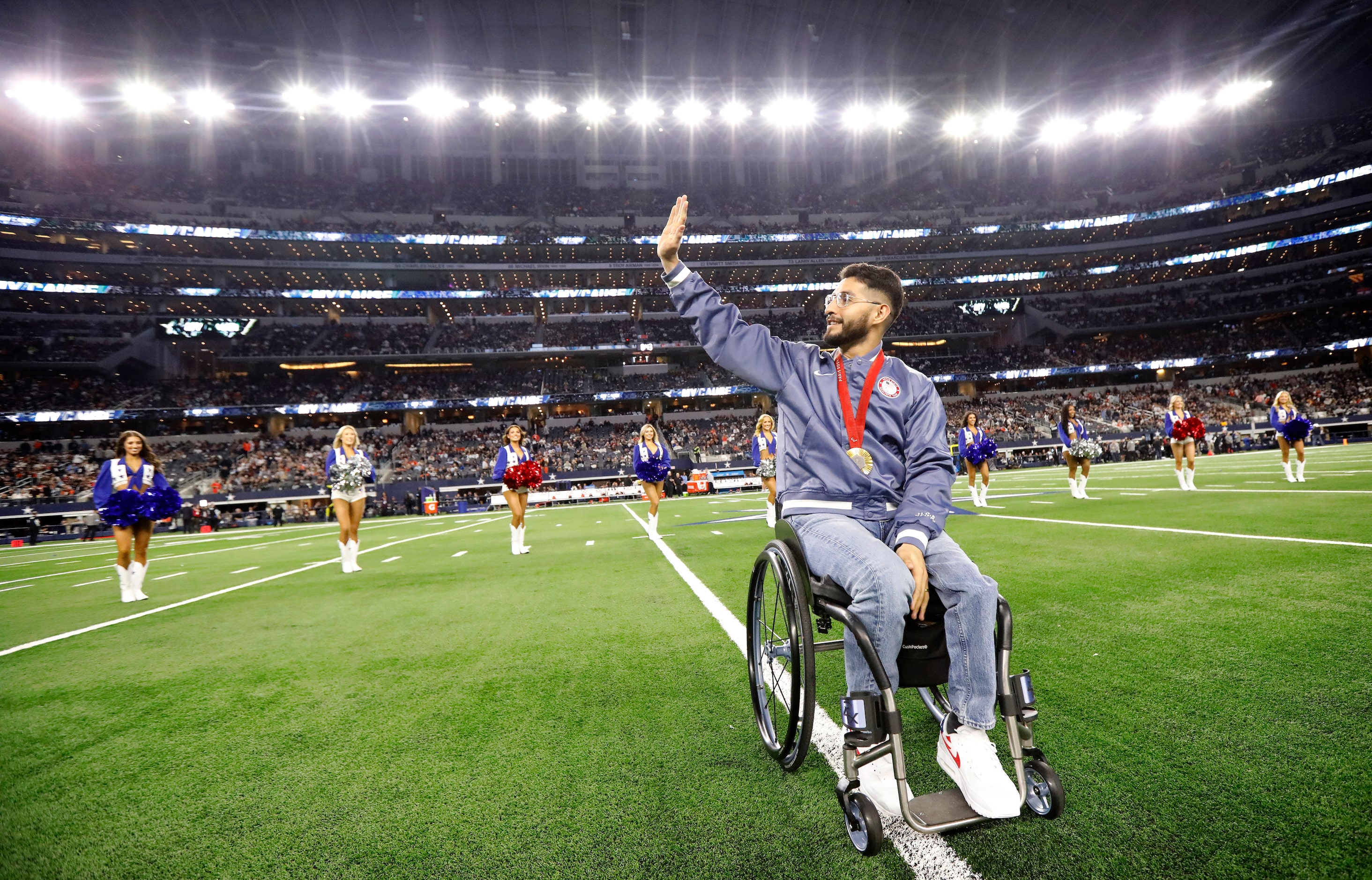 Gold medal wheelchair basketball team member Fabian Romo waves to crowd after being...