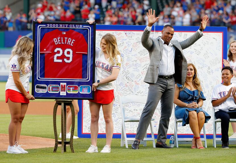 Former Texas Rangers player Adrian Beltre acknowledges cheers from fans as his wife, Sandra,...