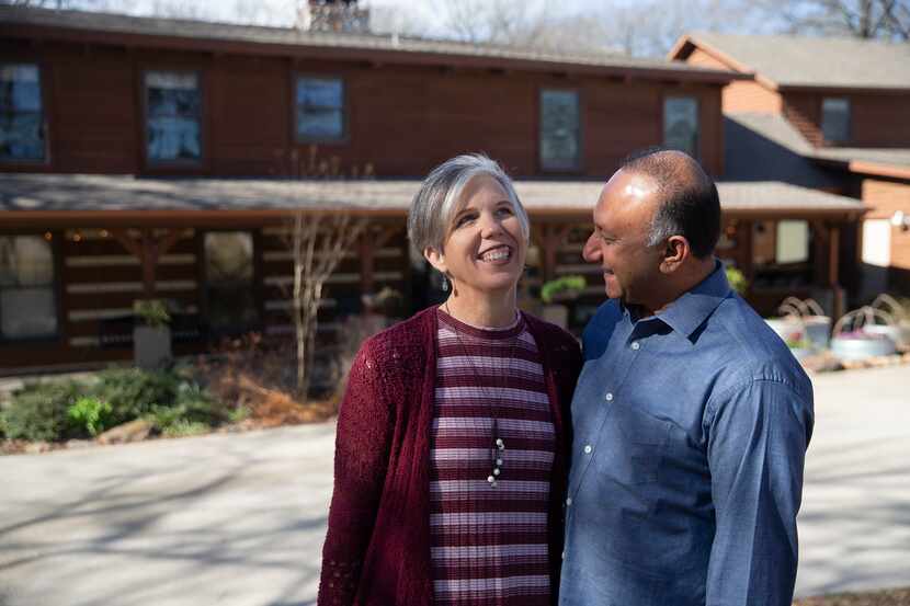 Ali Master and his wife, Judy, laugh while posing for photos at their log cabin home in...