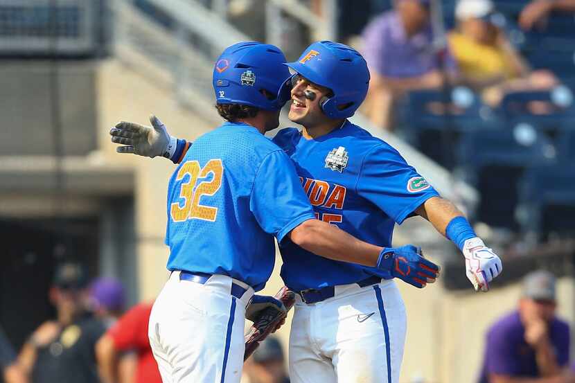 Florida's BT Riopelle is greeted by Tucker Talbott (32) after hitting a home run during the...