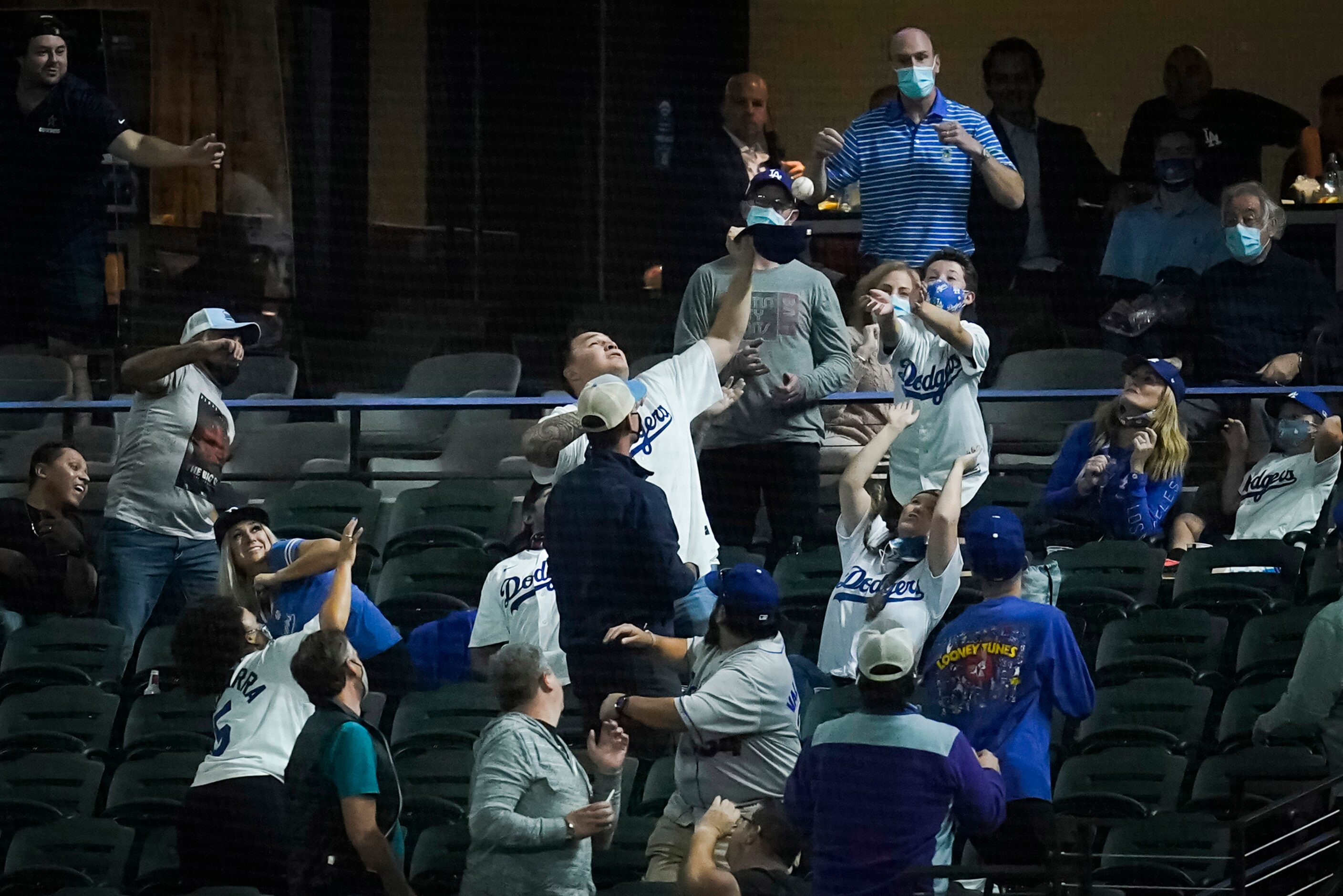 A Los Angeles Dodgers fan makes a catch with his cap on a foul ball off the bat of Tampa Bay...