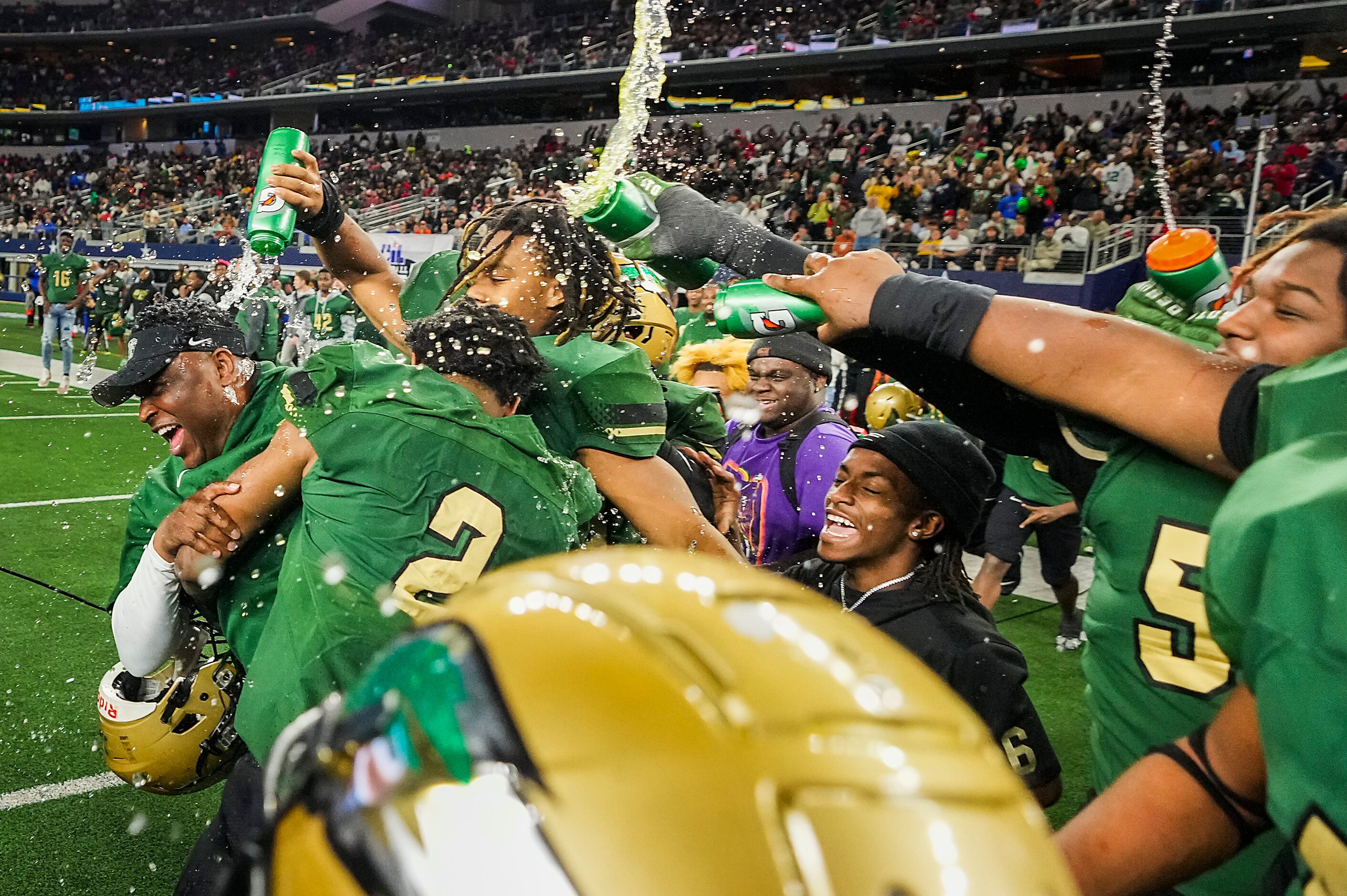 DeSoto head coach Claude Mathis is doused with water bottles by his players after a victory...