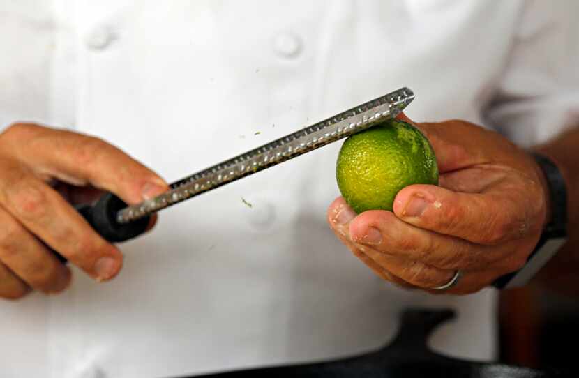 Chef Ken Rathbun zests lime onto dough brushed with butter as he makes ancho chili-lime...