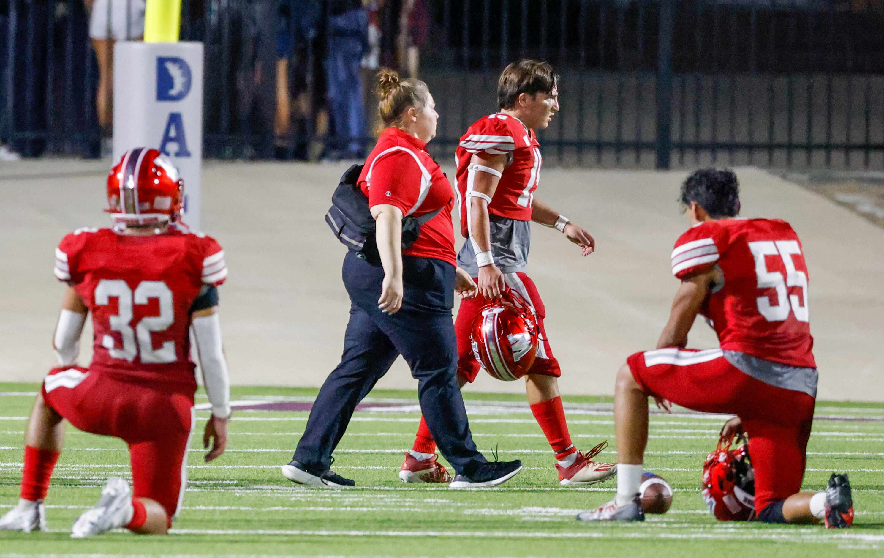 Players take a knee as Woodrow Wilson defensive back Jacob Crissey (19) exits the field for...