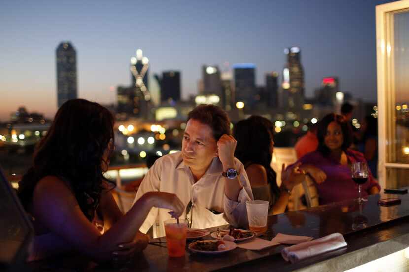 Lu Lira, left, talks with Raul Gomez on the rooftop bar of the NYLO Dallas South Side hotel...