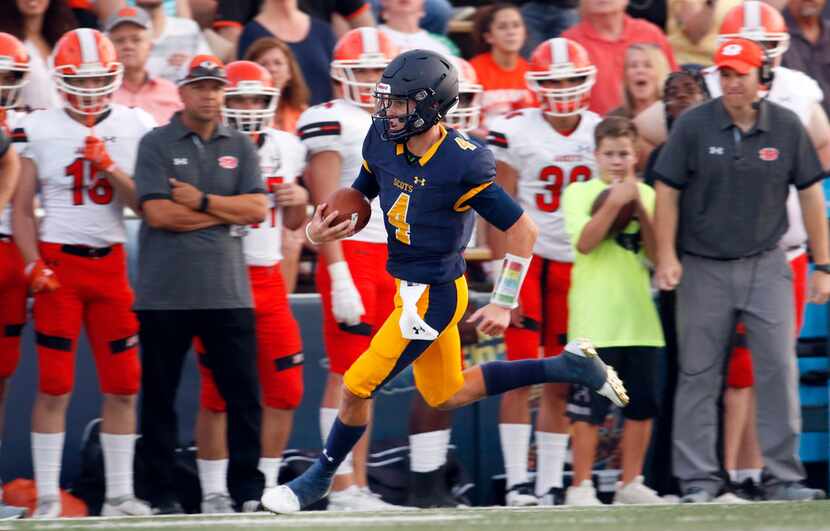 Highland Park quarterback Chandler Morris (4) scampers past the Rockwall bench enroute to a...