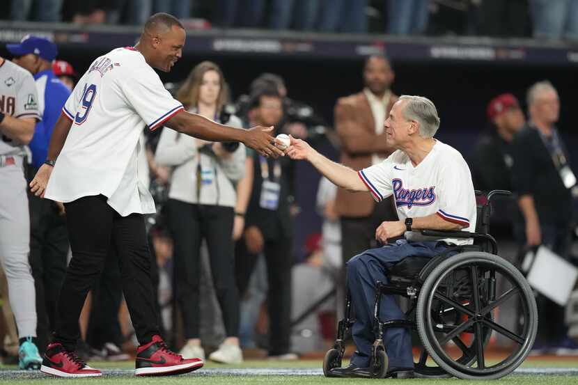 Former Texas Rangers third baseman Adrián Beltré receives a baseball from Governor Greg...