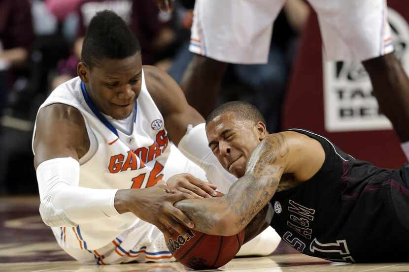 Florida's Will Yeguete (15) and Texas A&M's J'Mychal Reese (11) battle for a loose ball...