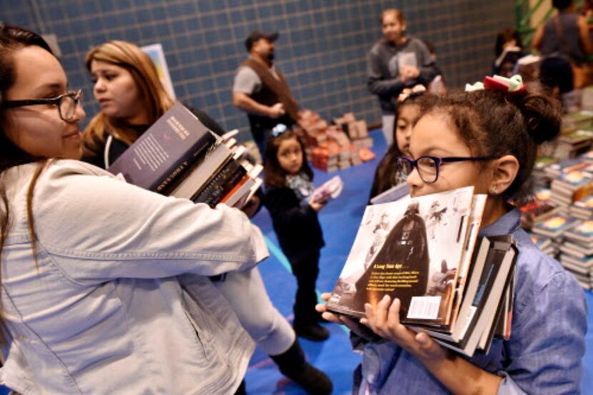 Celina Morantes (izq.) y su hija Alazy, de 7 años, se llevan varios libros durante un...