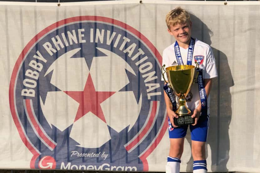 Jake Rhine, son of FC Dallas legend Bobby Rhine, holding the championship trophy for his age...
