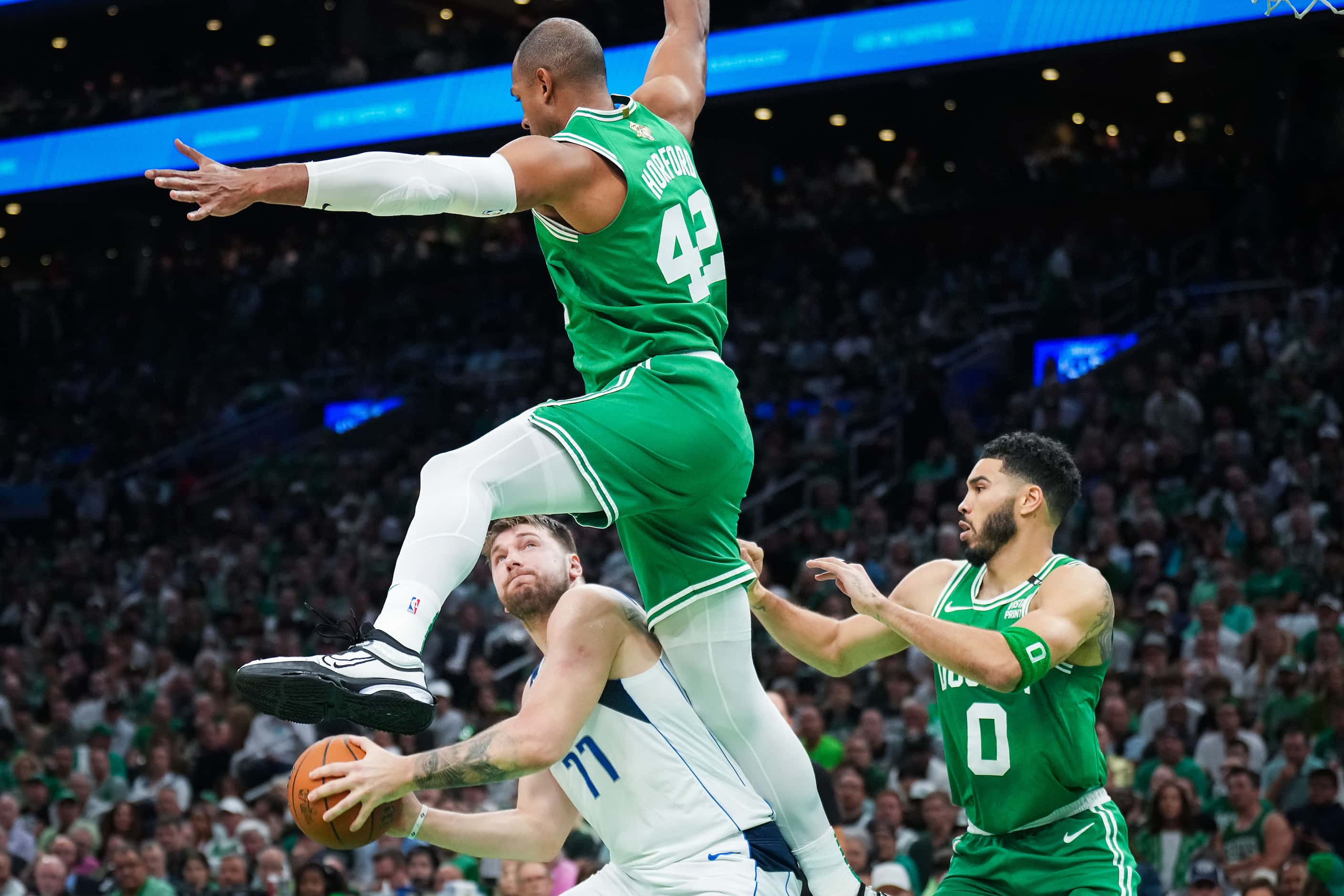Dallas Mavericks guard Luka Doncic (77) is defended by Boston Celtics center Al Horford (42)...