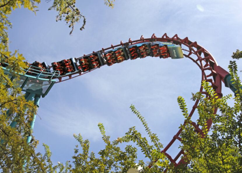 Patrons ride the Flashback at Six Flags Over Texas in Arlington. The Texas Chute Out and the...