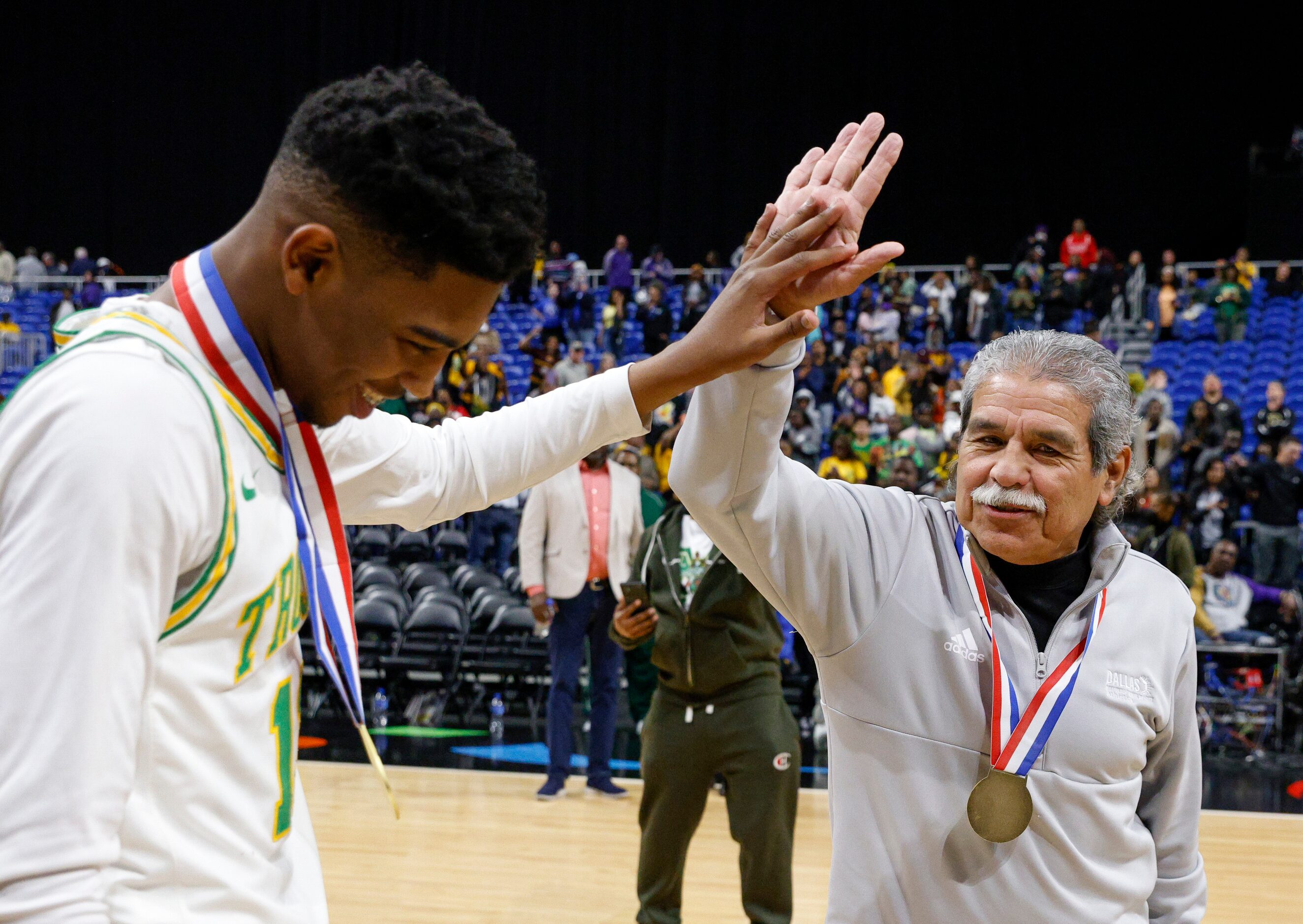 Madison forward Rodney Geter (13) high-fives Dallas ISD Superintendent Michael Hinojosa as...