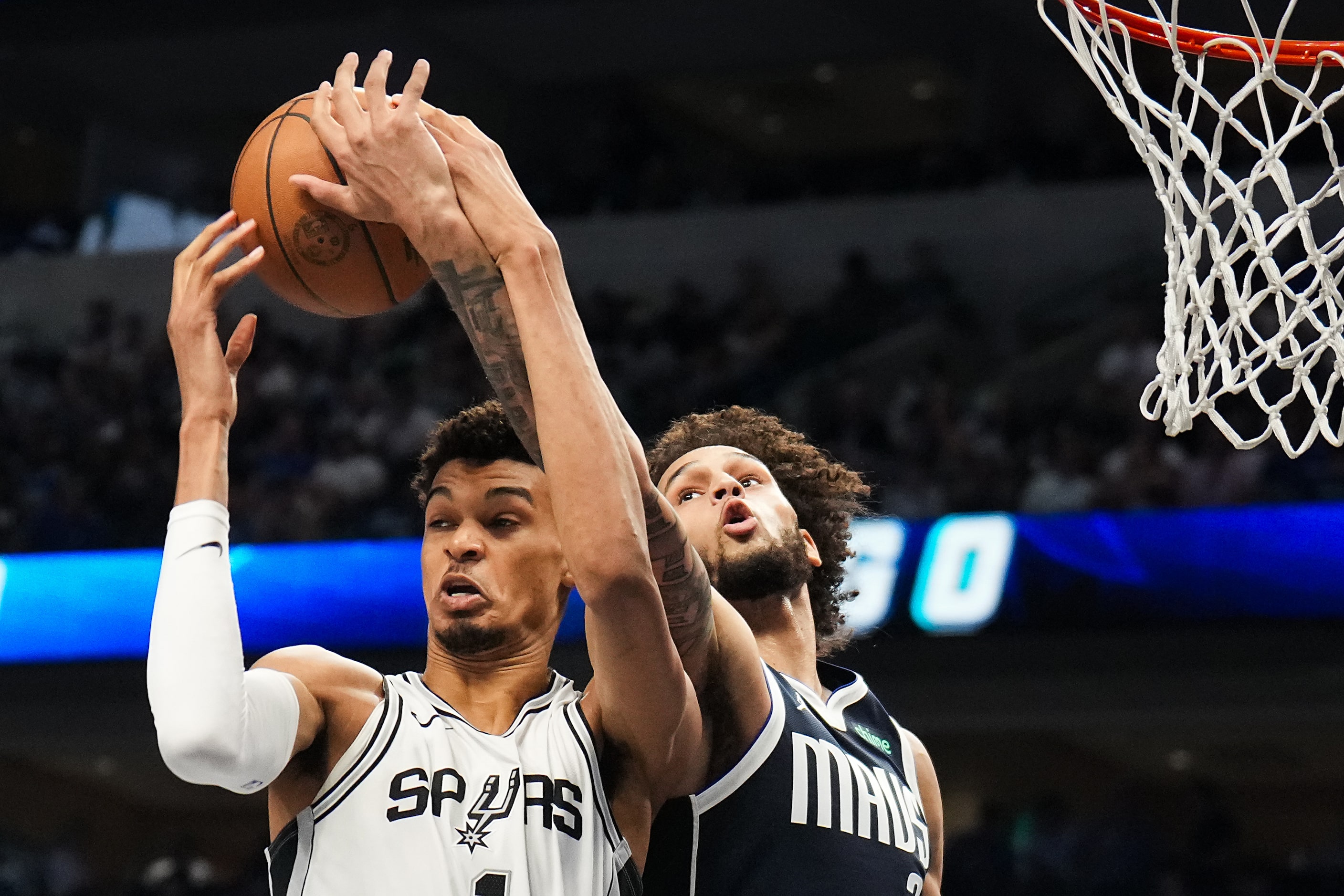 San Antonio Spurs center Victor Wembanyama (1) fights for a rebound against Dallas Mavericks...