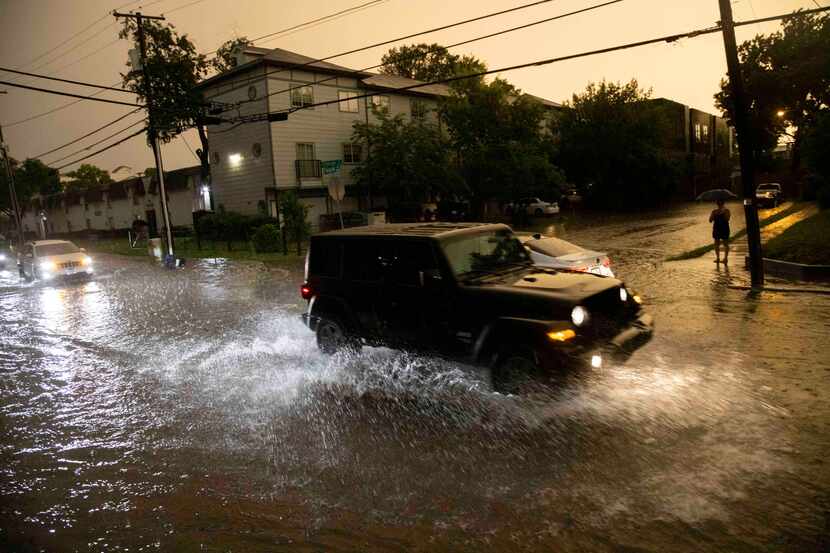 Vehicles drive through flooded streets in Old East Dallas following Sunday's severe storms.