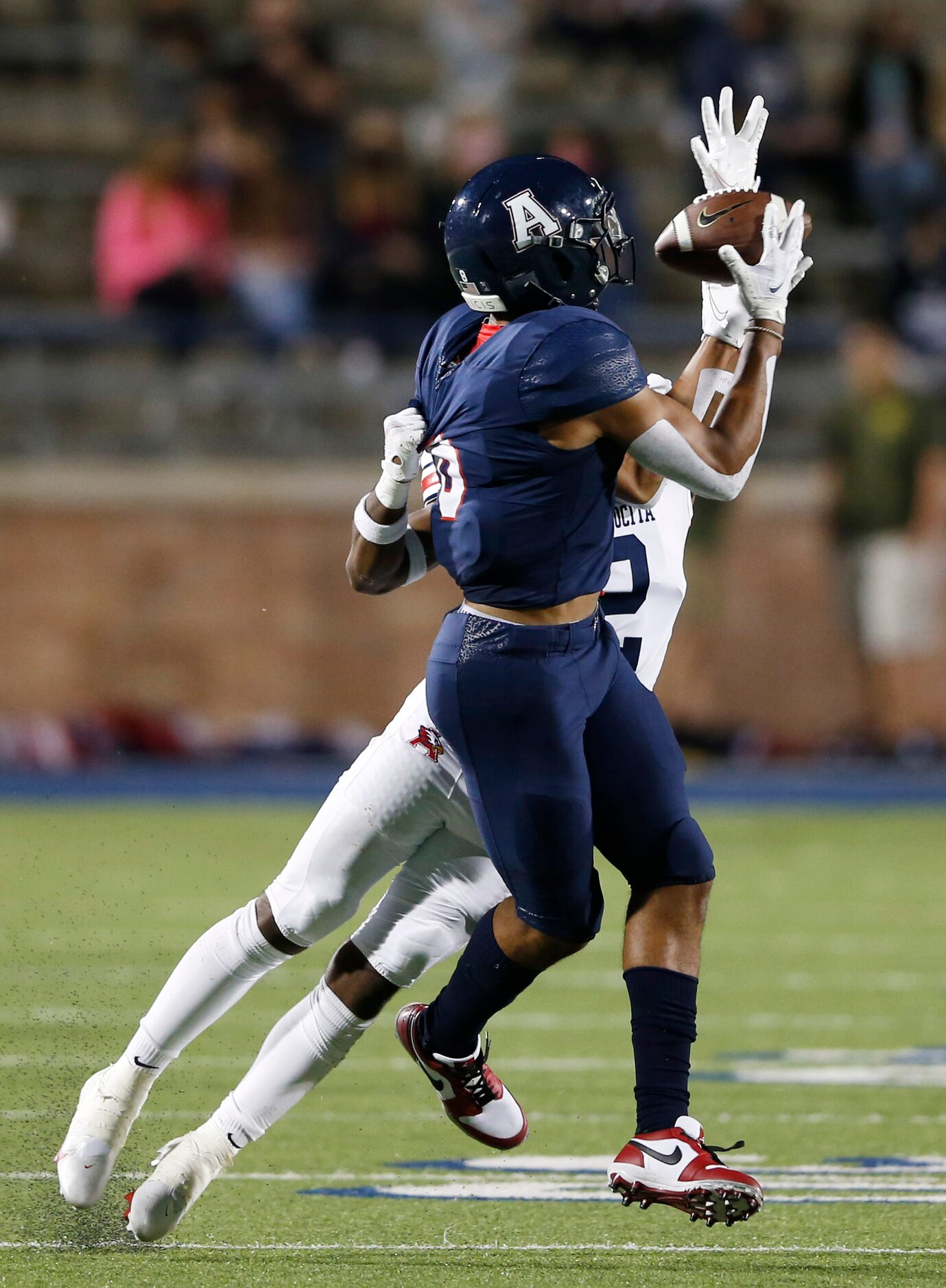 Allen's Blaine Green (8) catches a pass as Humble Atascocita's Caleb Burton (2) grabs the...