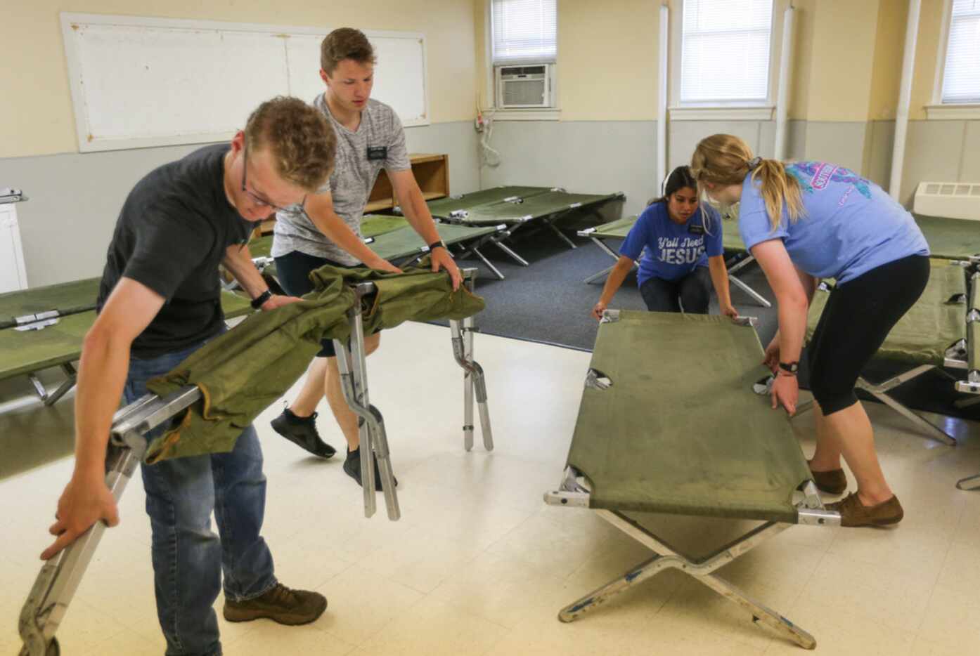 Volunteers from the Church of Jesus Christ of Latter-day Saints set up cots at Oak Lawn...