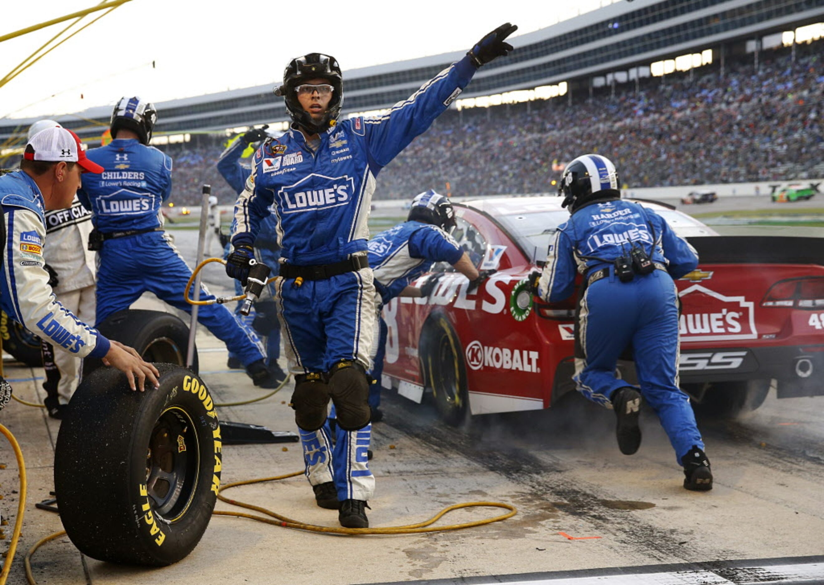 Crewman for Sprint Cup Series driver Jimmie Johnson (48) cheer as they get their car back on...