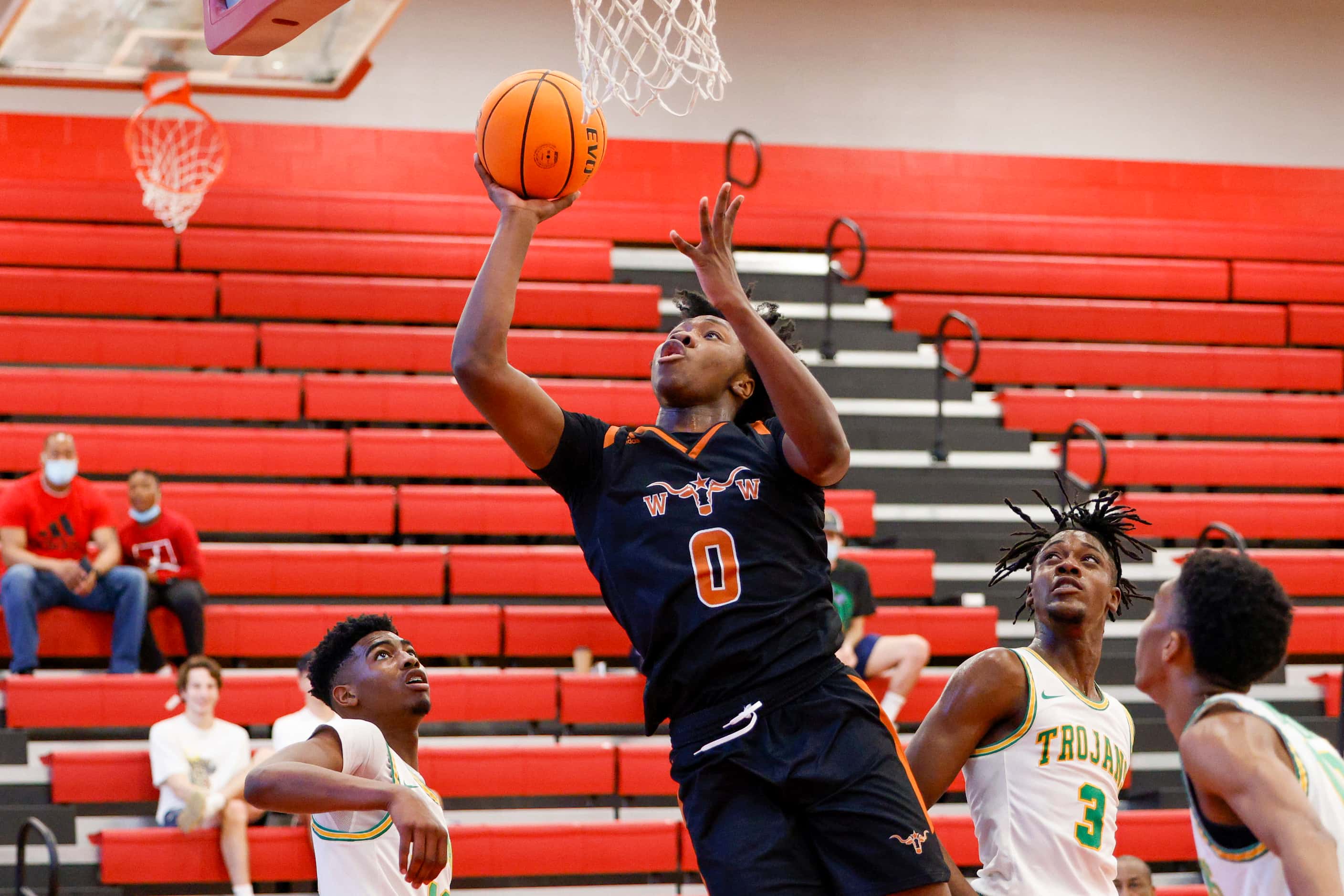 W.T. White forward Dre Cole (0) drives to the basket over Madison forwards Leonard Miles IV...