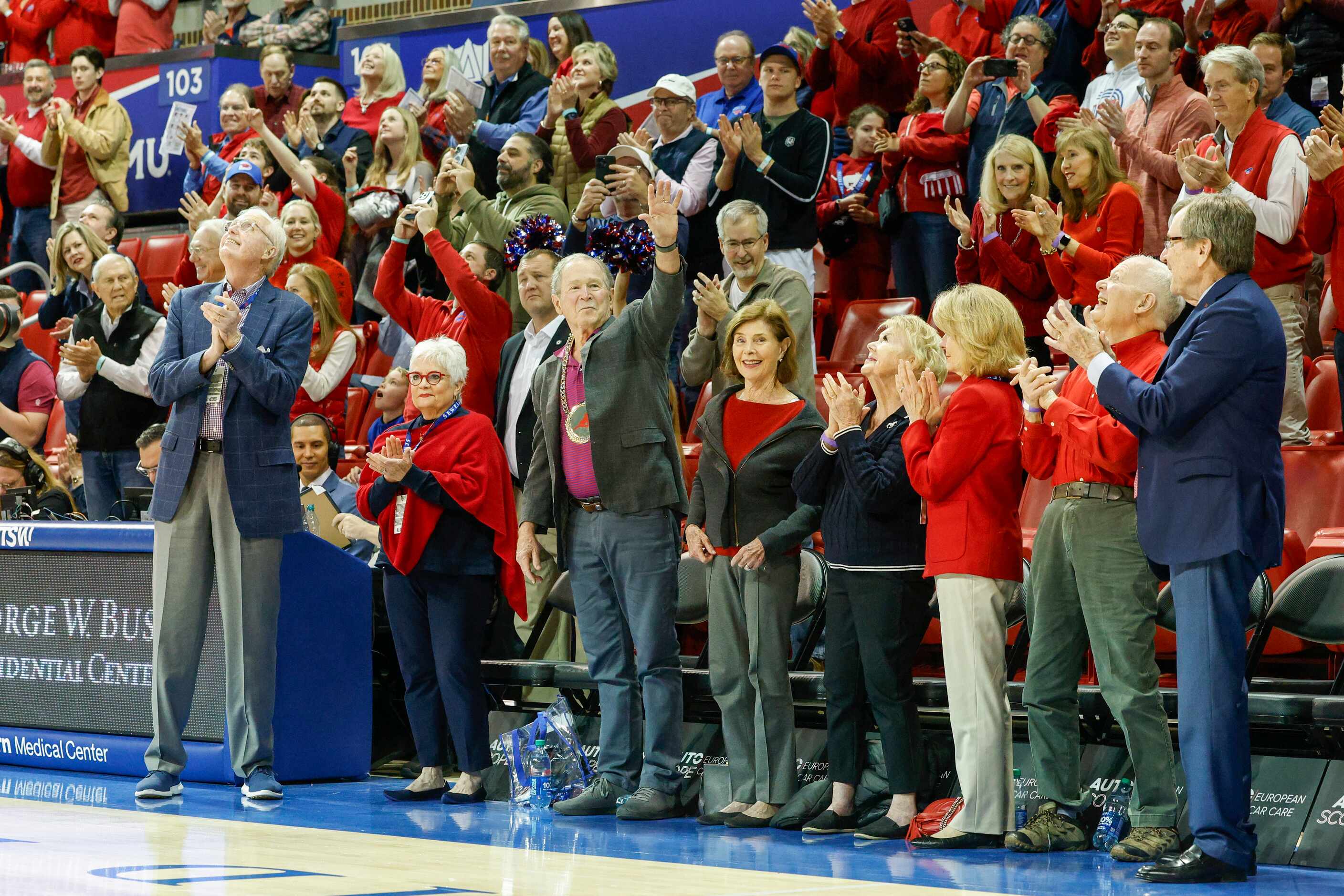 Former President George W. Bush waves to the crowd while wearing a gold replica SMU chain as...