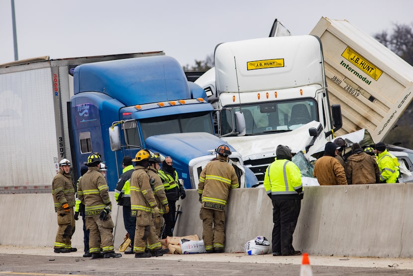 Emergency crews work to clear the mass casualty pile-up on I-35W and Northside Drive in Fort...