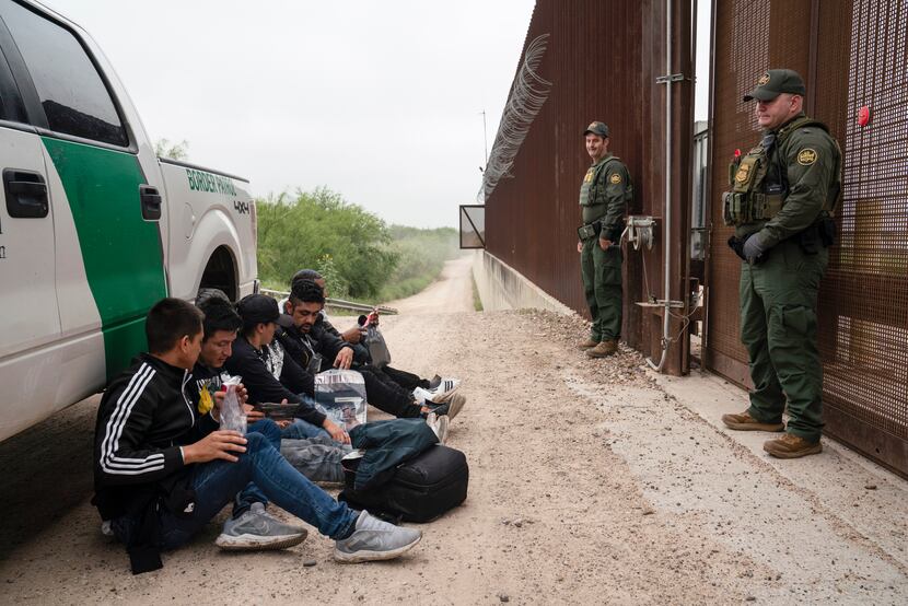 FILE - Colombian migrants that were trying to evade U.S. Border Patrol wait to be processed...