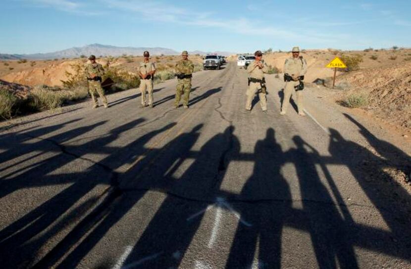 Protesters cast long shadows as they faced law officers blocking a road. Rancher Clive Bundy...
