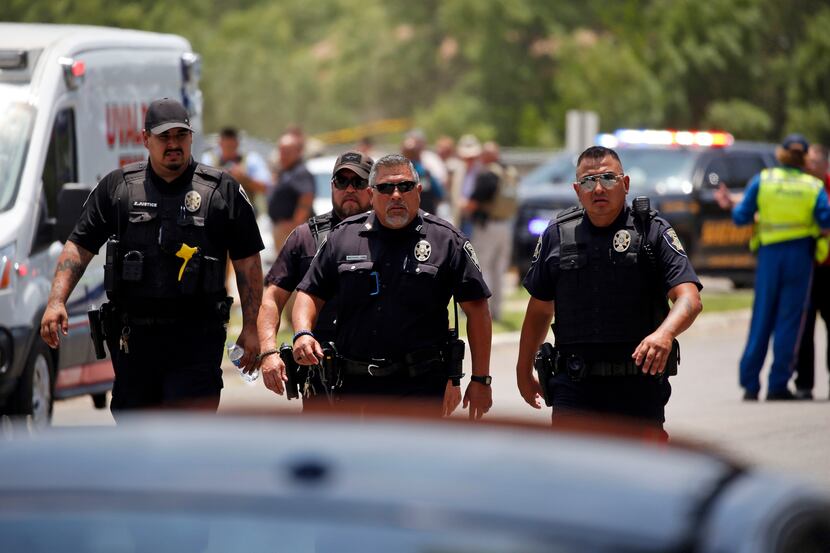 Police walked near Robb Elementary School in Uvalde after the shooting that killed 19...