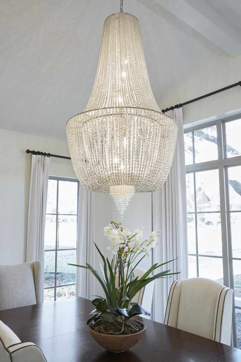 Add sparkle, light and elegance with a chandelier centered over a dining table, says...