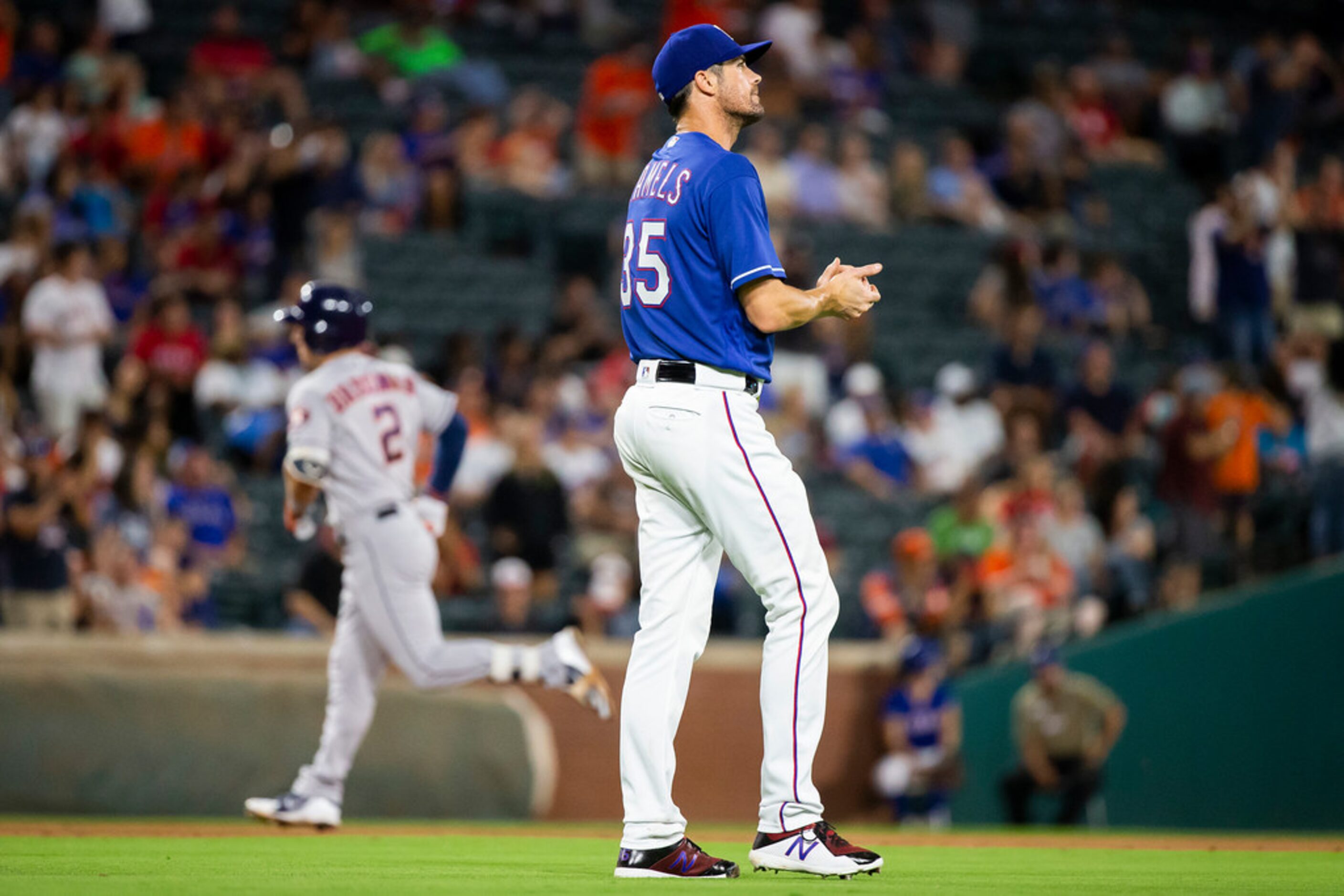 Texas Rangers starting pitcher Cole Hamels reacts after a home by Houston Astros third...