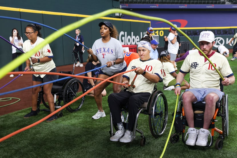 Shelby Estocado (center) and Nick Ferris (right) participate in a battle rope exercise...