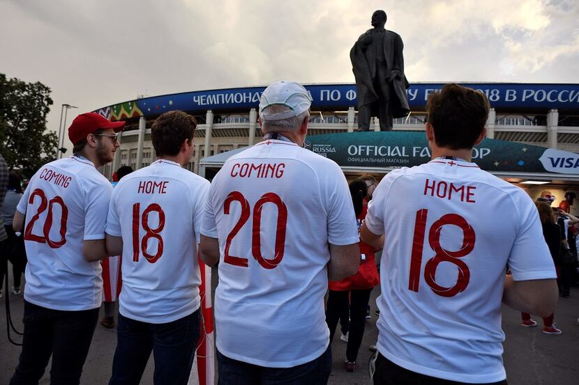 England's fans pose with their jerseys reading "Coming Home" outside the stadium before the...