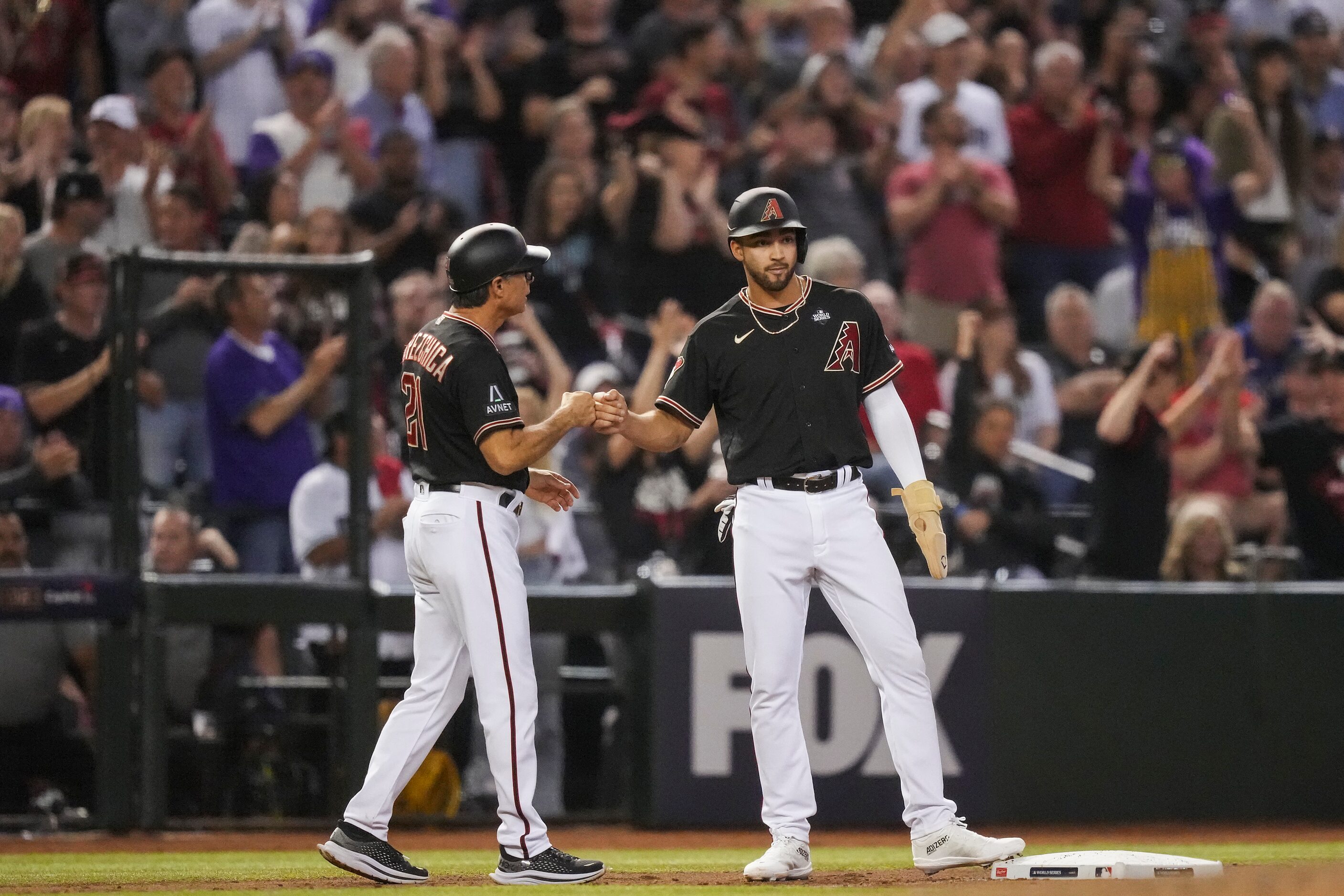 Arizona Diamondbacks pinch hitter Jordan Lawlar fist bumps third base coach Tony Perezchica...