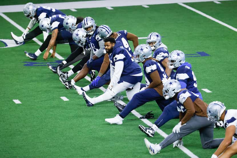 Dallas Cowboys players warm up during a practice at The Star, Wednesday, Jan. 10, 2024 in...