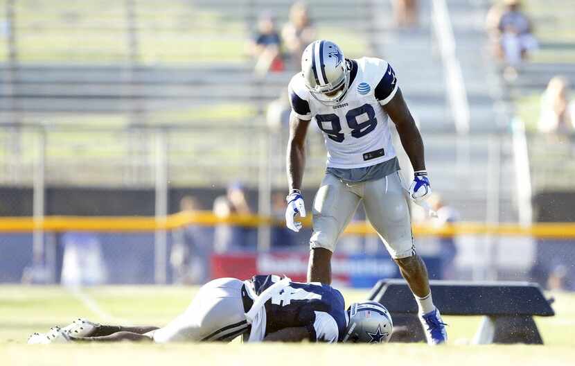 Dallas Cowboys wide receiver Dez Bryant (88) stands over cornerback Morris Claiborne (24)...