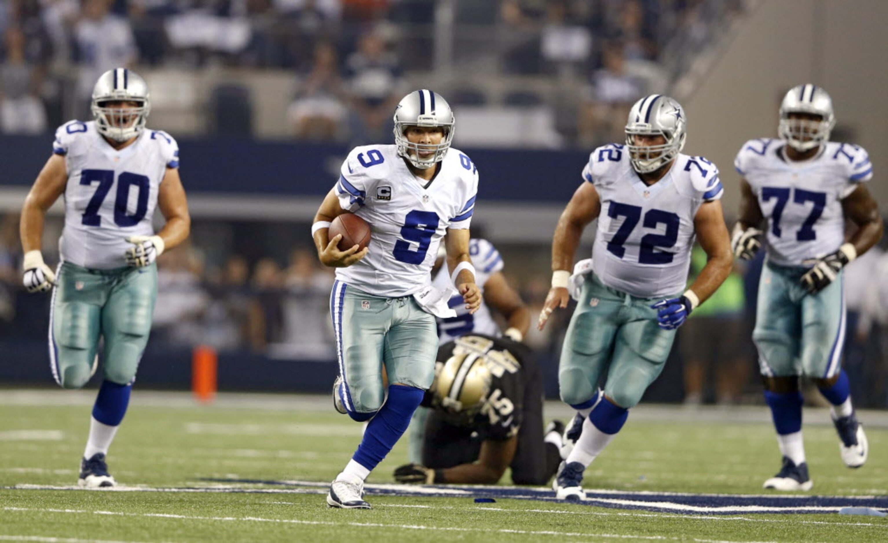 Dallas Cowboys quarterback Tony Romo (9) breaks away for a 21 yard rush in a game against...