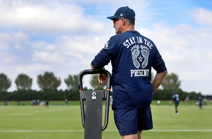 Dallas Cowboys defensive coordinator Mike Zimmer wears the Rooted mantra shirt with Stay In...