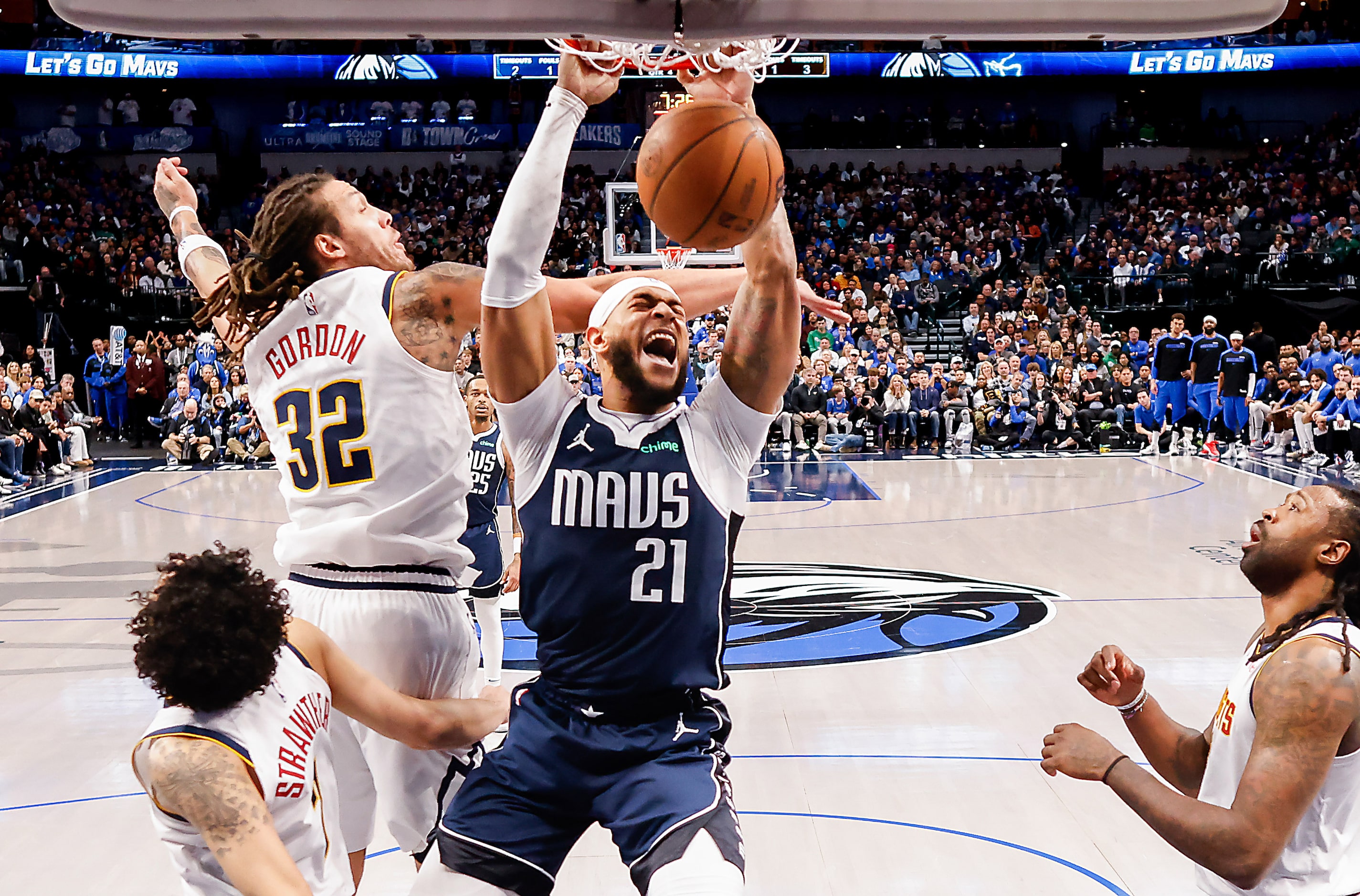 Dallas Mavericks center Daniel Gafford (21) dunks the ball past Denver Nuggets guard Julian...