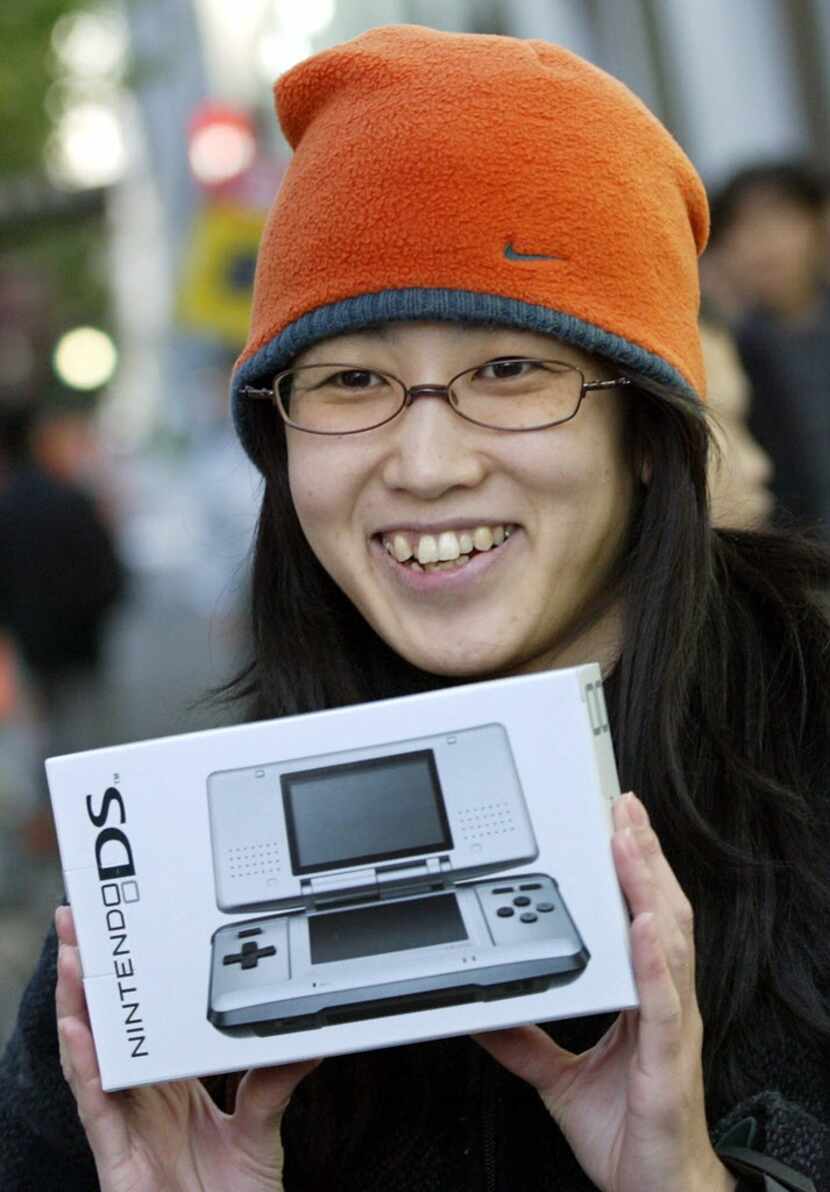 A woman smiles after she purchased the new Nintendo DS video game device in Tokyo, 02...