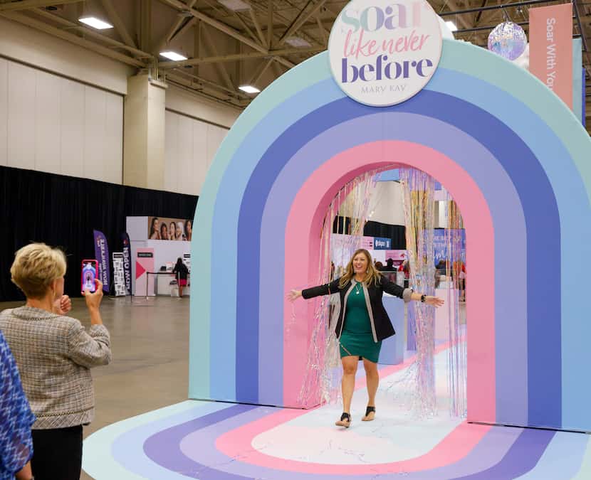 Janelle Kennedy of Pennsylvania emerges from a photo booth at the annual Mary Kay Seminar at...
