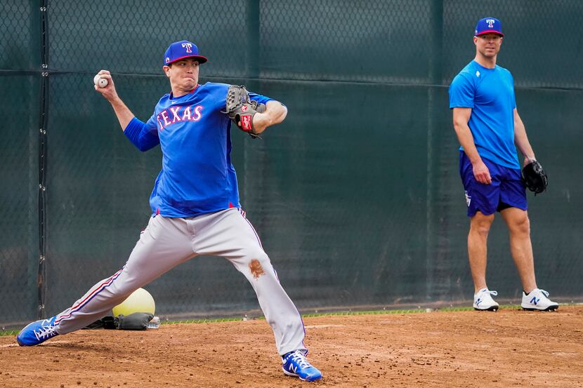 Texas Rangers pitcher Corey Kluber (right) watches teammate Kyle Gibson throw in the bullpen...