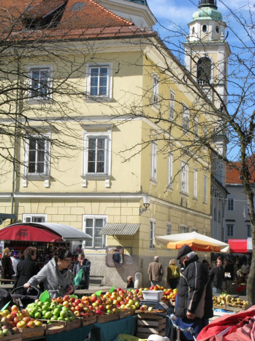 Steps from St. Nicholas Cathedral, a customer shops for apples in Ljubljana's Central Market.